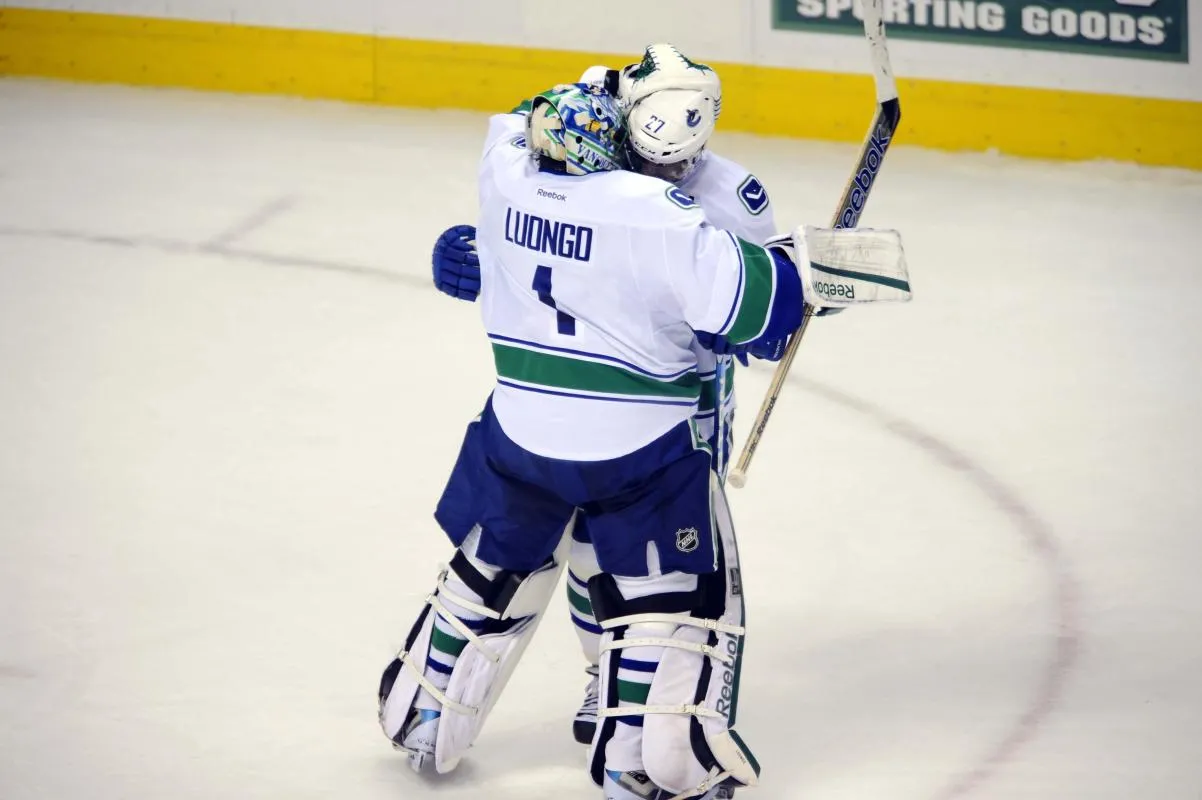 Vancouver Canucks goalie Roberto Luongo (1) is congratulated by center Manny Malhotra (27) after the game against the Colorado Avalanche at the Pepsi Center. The Canucks defeated the Avalanche 3-2 in a shootout.