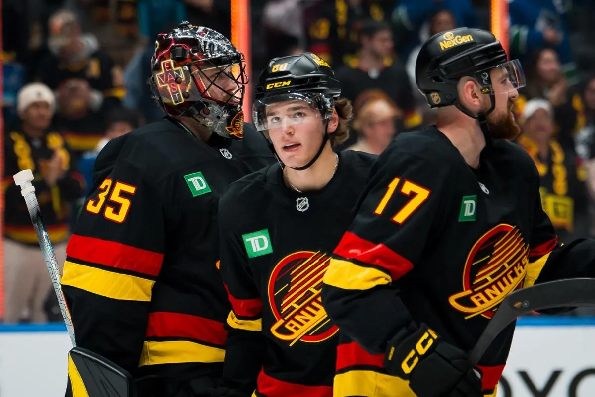 Vancouver Canucks goalie Thatcher Demko (35) and forward Braeden Cootes (80) and defenseman Filip Hronek (17) celebrate thier victory against the Calgary Flames at Rogers Arena.