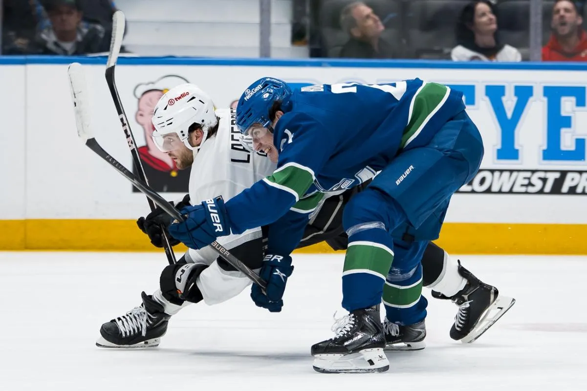 Vancouver Canucks defenseman Zeev Buium (24) battles with Los Angeles Kings forward Alex Laferriere (14) in the third period at Rogers Arena.