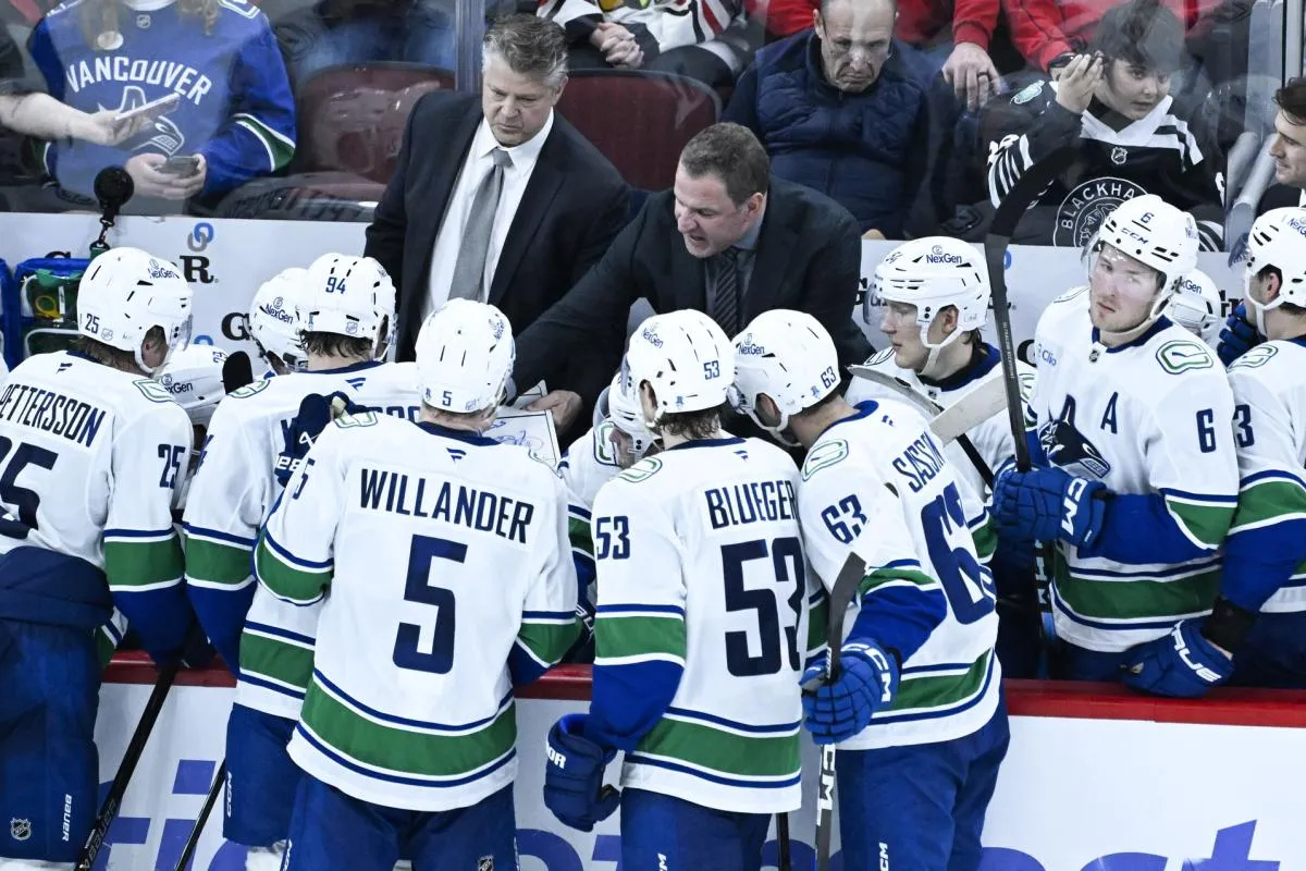 Vancouver Canucks head coach Adam Foote, right, talks with his team during the third period against the Chicago Blackhawks at United Center.