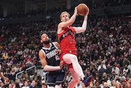 Toronto Raptors' Gradey Dick (1) shoots on Dallas Mavericks' Caleb Martin (16) during first...
