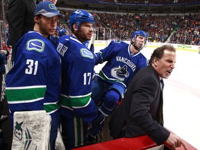 Eddie Lack, Ryan Kesler and Alex Burrows watch Vancouver Canucks head coach John Tortorella as he exchanges words with players and coaches of the Calgary Flames on Jan. 18, 2014 at Rogers Arena.