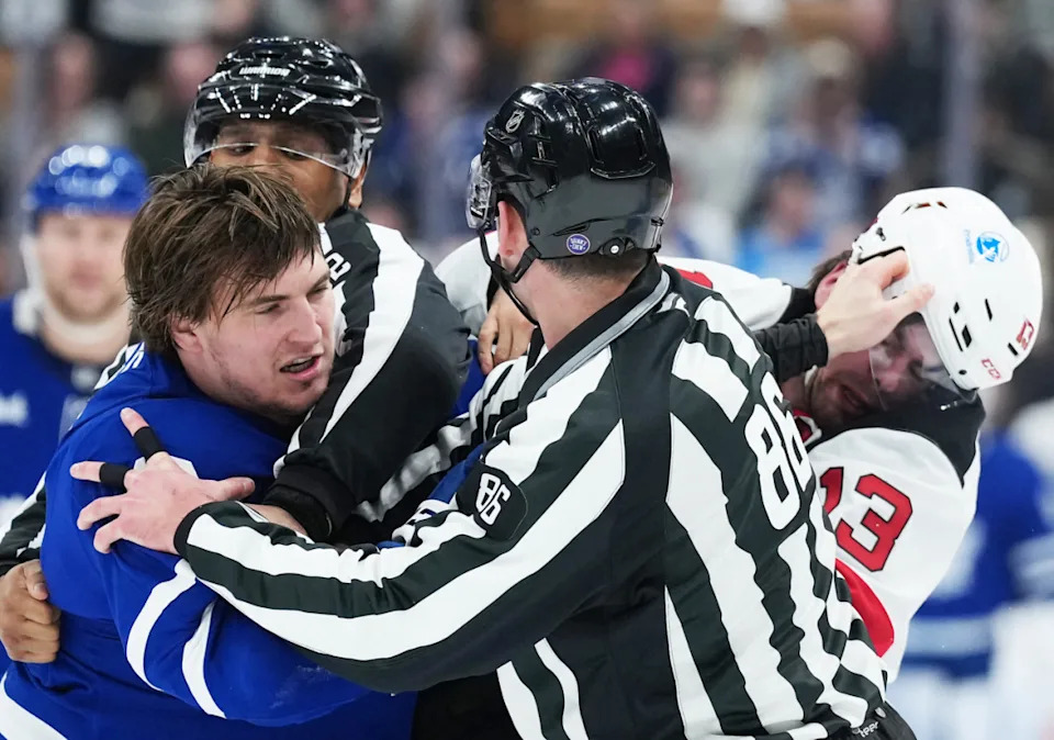Toronto Maple Leafs left wing Matthew Knies (23) fights with New Jersey Devils center Nico Hischier (13) during the third period at Scotiabank Arena.Nick Turchiaro-Imagn Images