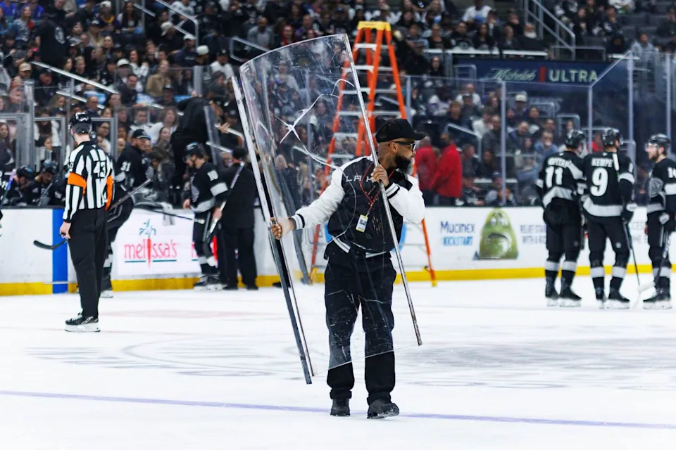 Los Angeles Kings maintenance crew members switches out a glass panel during an NHL match against the Utah Mammoth on March 28, 2026 in Los Angeles, California.