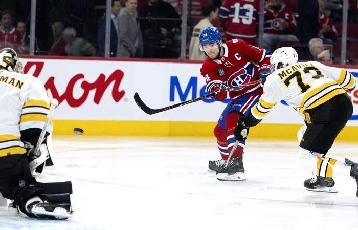  Montreal Canadiens centre Nick Suzuki fires a shot on Boston Bruins goaltender Jeremy Swayman despite being pressured by Bruins defenceman Charlie McAvoy during the third period at the Bell Centre on Tuesday, March 17, 2026.