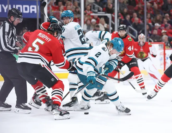 Feb 2, 2026; Chicago, Illinois, USA; Chicago Blackhawks defenseman Connor Murphy (5) and San Jose Sharks center Will Smith (2) battle for control of the puck during the second period at United Center.