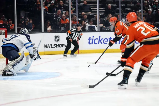 Feb 27, 2026; Anaheim, California, USA; Anaheim Ducks left wing Cutter Gauthier (61) looks to shoot the puck against Winnipeg Jets goaltender Connor Hellebuyck (37) during the first period at Honda Center.