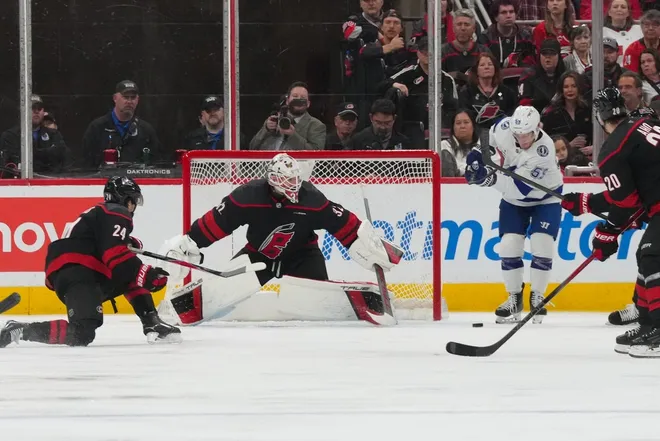 Feb 26, 2026; Raleigh, North Carolina, USA; Tampa Bay Lightning center Jake Guentzel (59) can’t control the puck next to Carolina Hurricanes goaltender Brandon Bussi (32) during the third period at Lenovo Center.