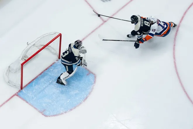Feb 28, 2026; Columbus, Ohio, USA; Columbus Blue Jackets defenseman Zach Werenski (8) skates with the puck against New York Islanders center Mathew Barzal (13) in the first period at Nationwide Arena.