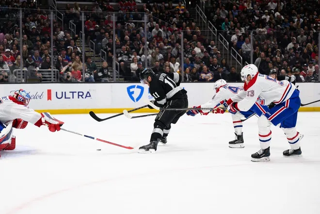 Mar 7, 2026; Los Angeles, California, USA; Los Angeles Kings center Anze Kopitar (11) looks to shoot the puck while under pressure from Montréal Canadiens defensemen Lane Hutson (48) and Noah Dobson (53) during the second period at Crypto.com Arena.