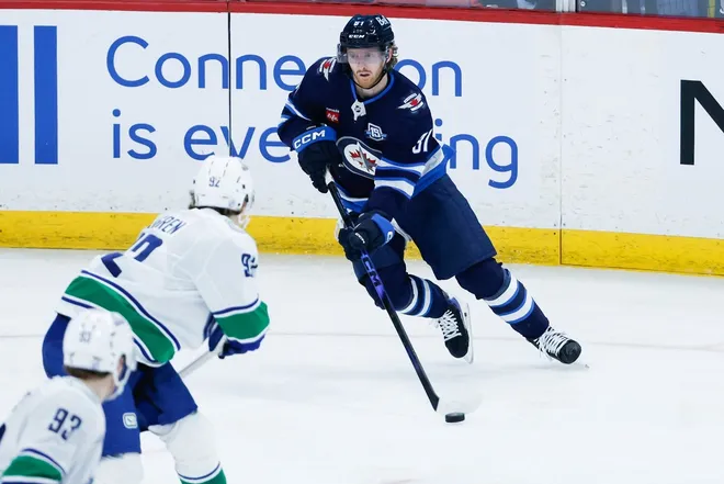 Mar 7, 2026; Winnipeg, Manitoba, CAN; Winnipeg Jets forward Kyle Connor (81) skates in on Vancouver Canucks forward Liam Ohgren (92) during the third period at Canada Life Centre.
