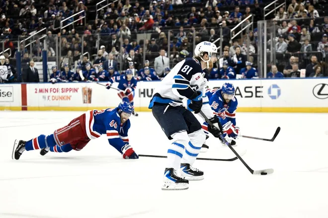 Mar 22, 2026; New York, New York, USA; Winnipeg Jets left wing Kyle Connor (81) skates with the puck while defended by New York Rangers defenseman Vladislav Gavrikov (44) and center Vincent Trocheck (16) during the third period at Madison Square Garden.