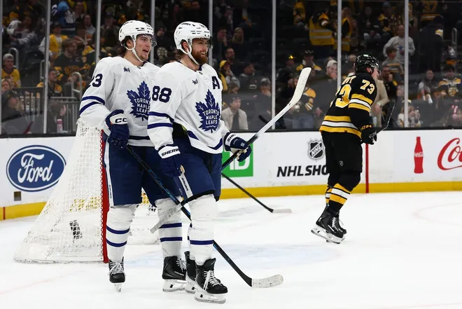 Mar 24, 2026; Boston, Massachusetts, USA; As Boston Bruins defenseman Charlie McAvoy (73) skates away, Toronto Maple Leafs right wing William Nylander (88) smiles with left wing Matthew Knies (23) after Knies scored during the third period at TD Garden.