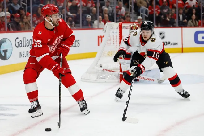 Mar 24, 2026; Detroit, Michigan, USA; Detroit Red Wings right wing Alex DeBrincat (93) skates with the puck defended by Ottawa Senators defenseman Jordan Spence (10) in the second period at Little Caesars Arena.