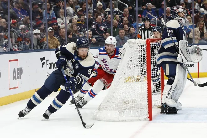 Mar 19, 2026; Columbus, Ohio, USA; Columbus Blue Jackets defenseman Ivan Provorov (9) skates with the puck as New York Rangers left wing Alexis Lafreniere (13) trails the play during the third period at Nationwide Arena.