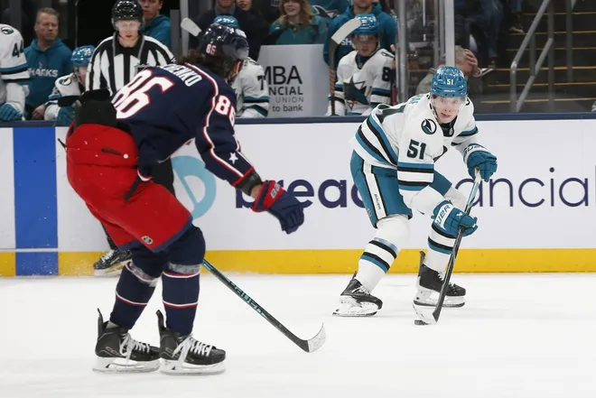 Mar 28, 2026; Columbus, Ohio, USA; San Jose Sharks right wing Collin Graf (51) looks to pass as Columbus Blue Jackets right wing Kirill Marchenko (86) defends during the second period at Nationwide Arena.