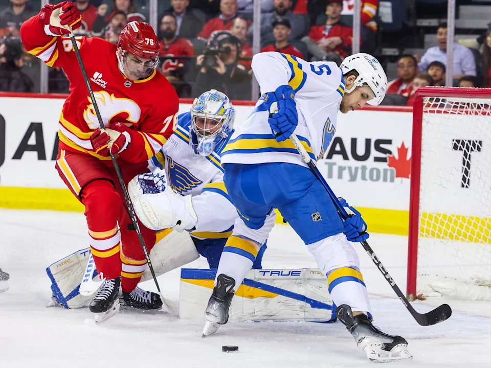  Calgary Flames forward Martin Pospisil reaches for the puck as St. Louis Blues goaltender Joel Hofer and defenceman Philip Broberg try to clear during NHL action at the Scotiabank Saddledome in Calgary on Wednesday, March 18, 2026.Gavin Young/Postmedia
