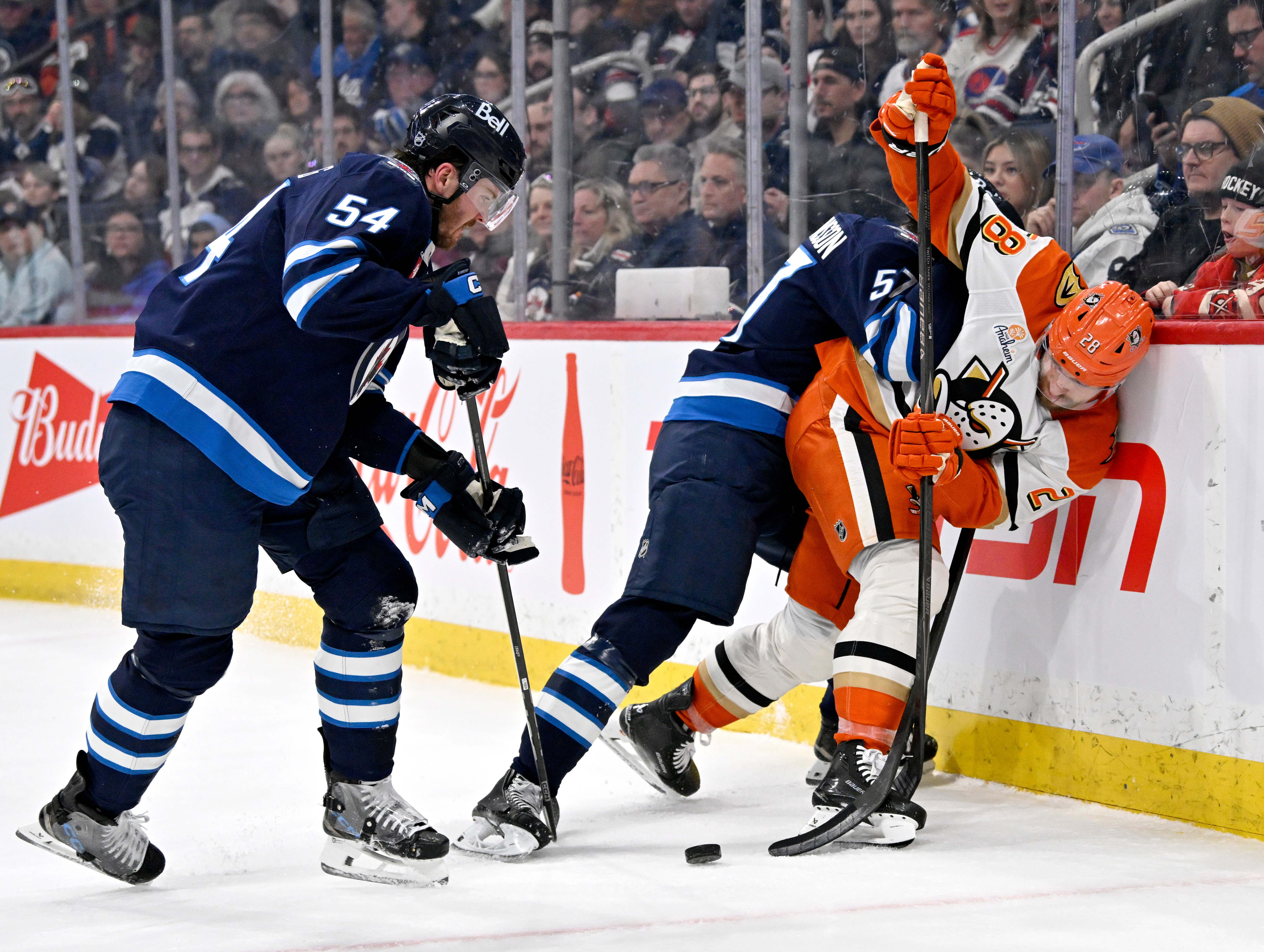 The Ducks’ Jeffrey Viel, right, is checked by the Winnipeg...