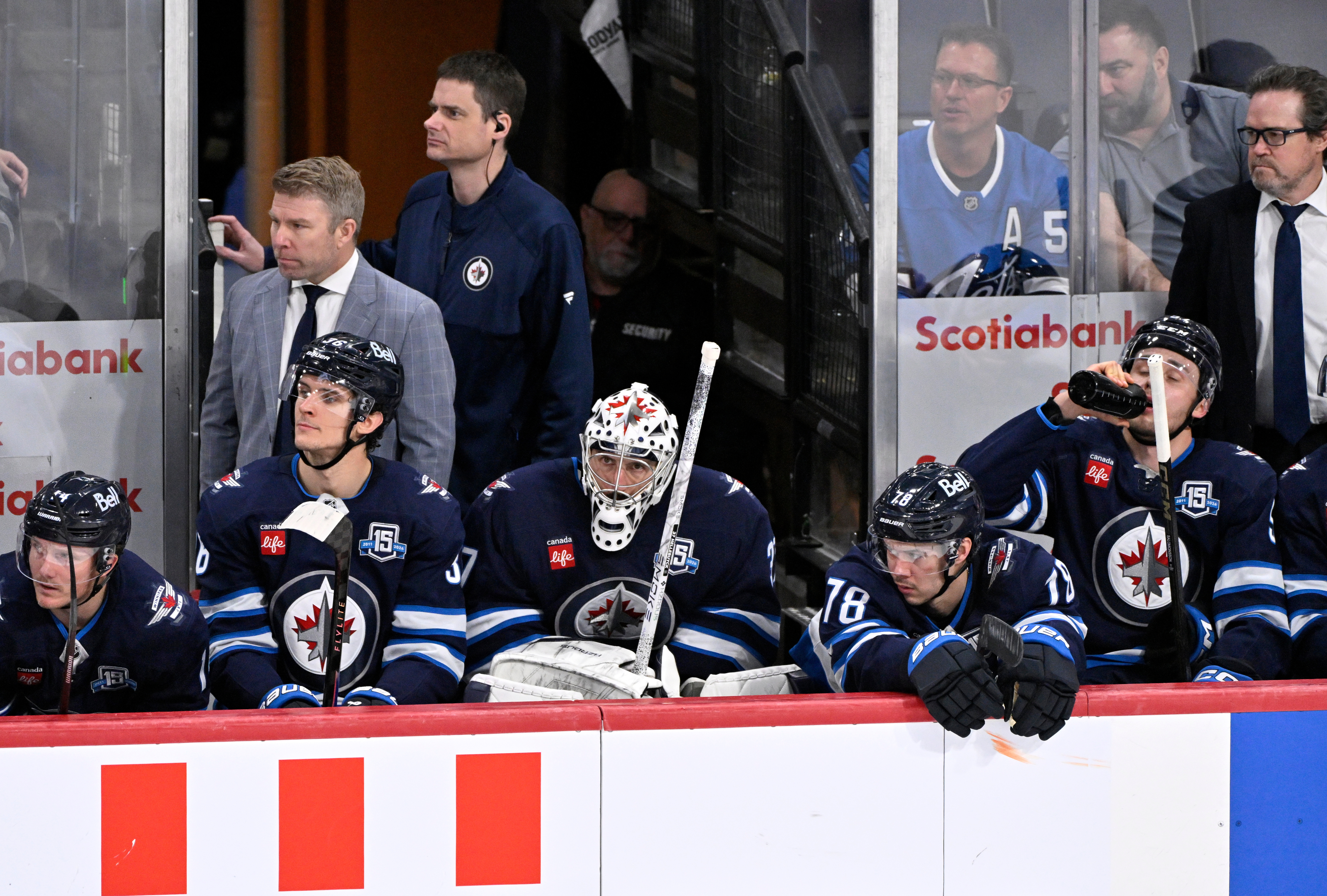 Winnipeg Jets goaltender Connor Hellebuyck (37) sits on the bench...