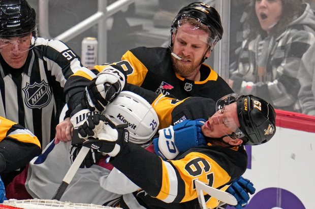 The Avalanche's Logan O'Connor fights with the Penguins' Rickard Rakell (67) and Anthony Mantha (39) during the third period of an NHL game Tuesday night in Pittsburgh. (AP Photo/Gene J. Puskar)