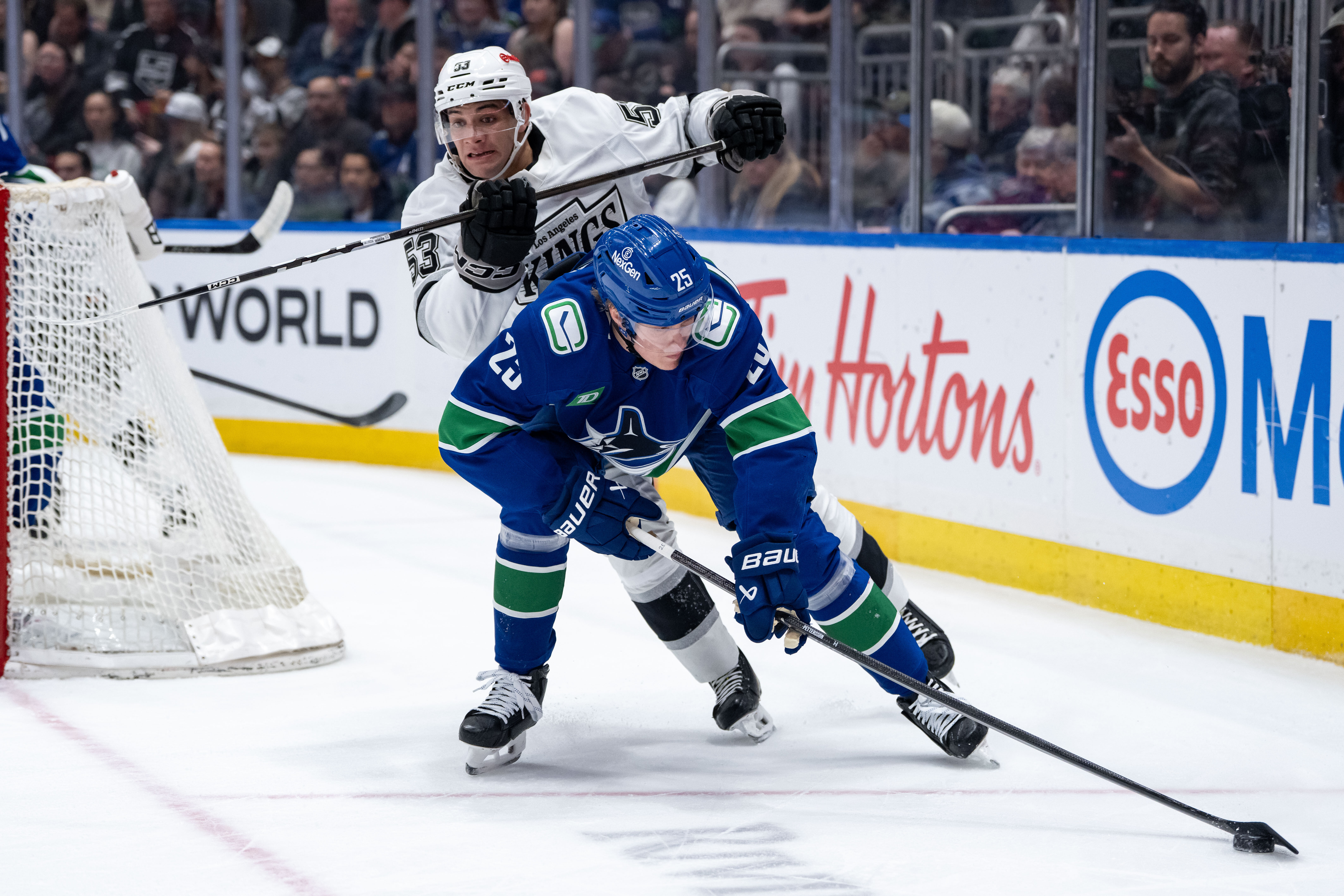 The Kings’ Jared Wright, top, and the Vancouver Canucks’ Elias...