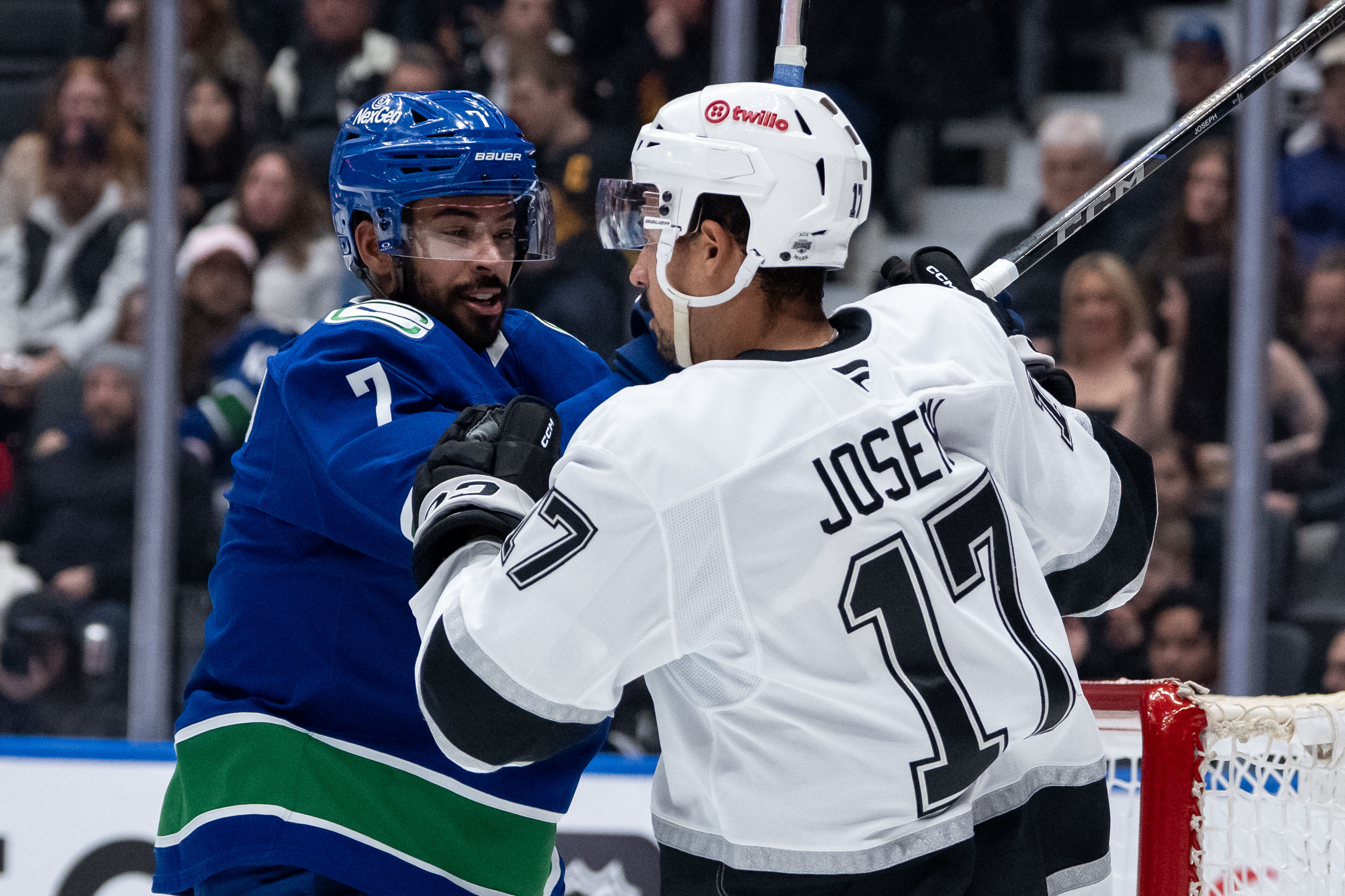 The Vancouver Canucks’ Pierre-Olivier Joseph, left, hits the Kings’ Mathieu...