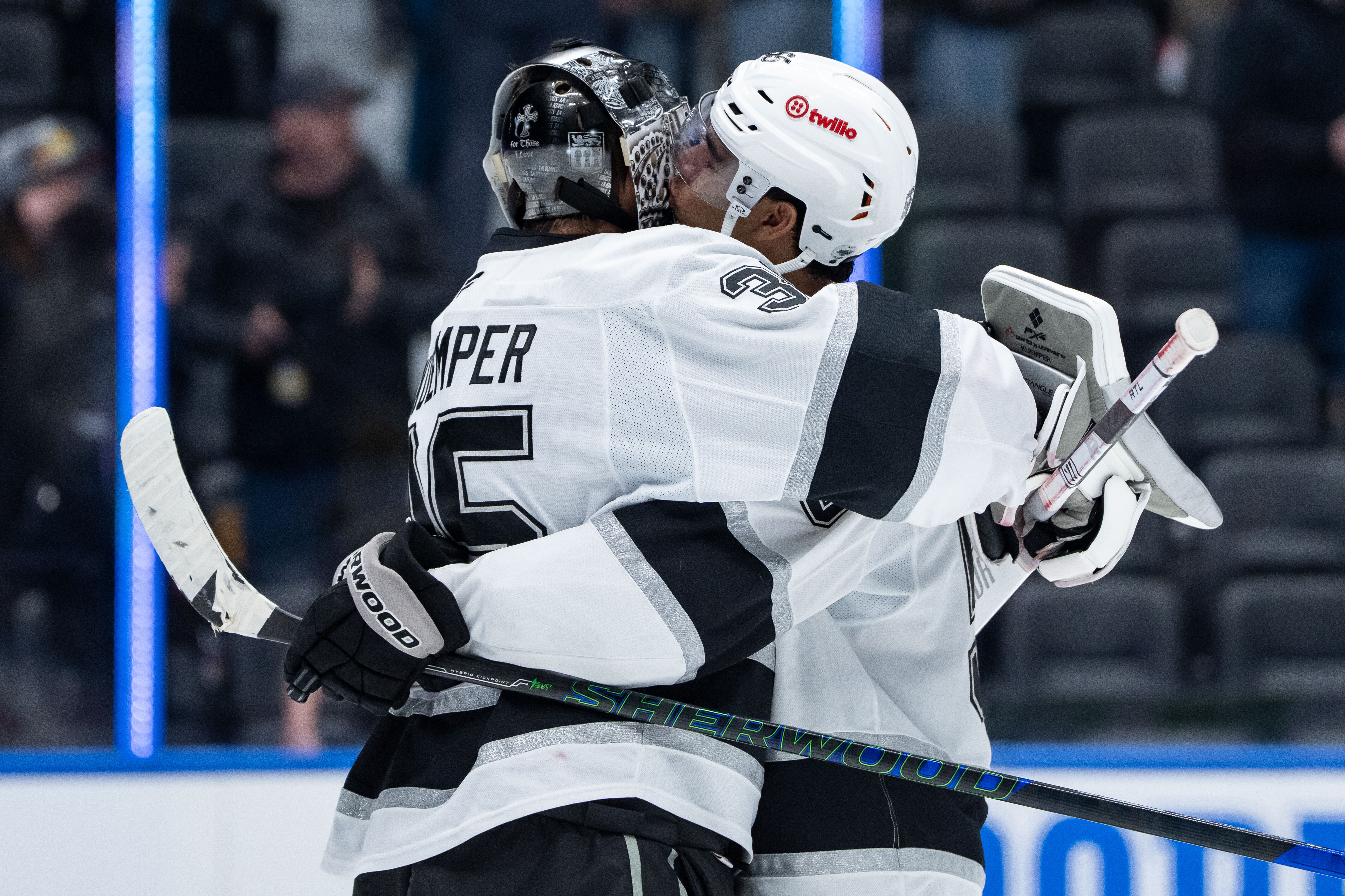 The Kings’ Quinton Byfield, right, kisses the helmet of goaltender...