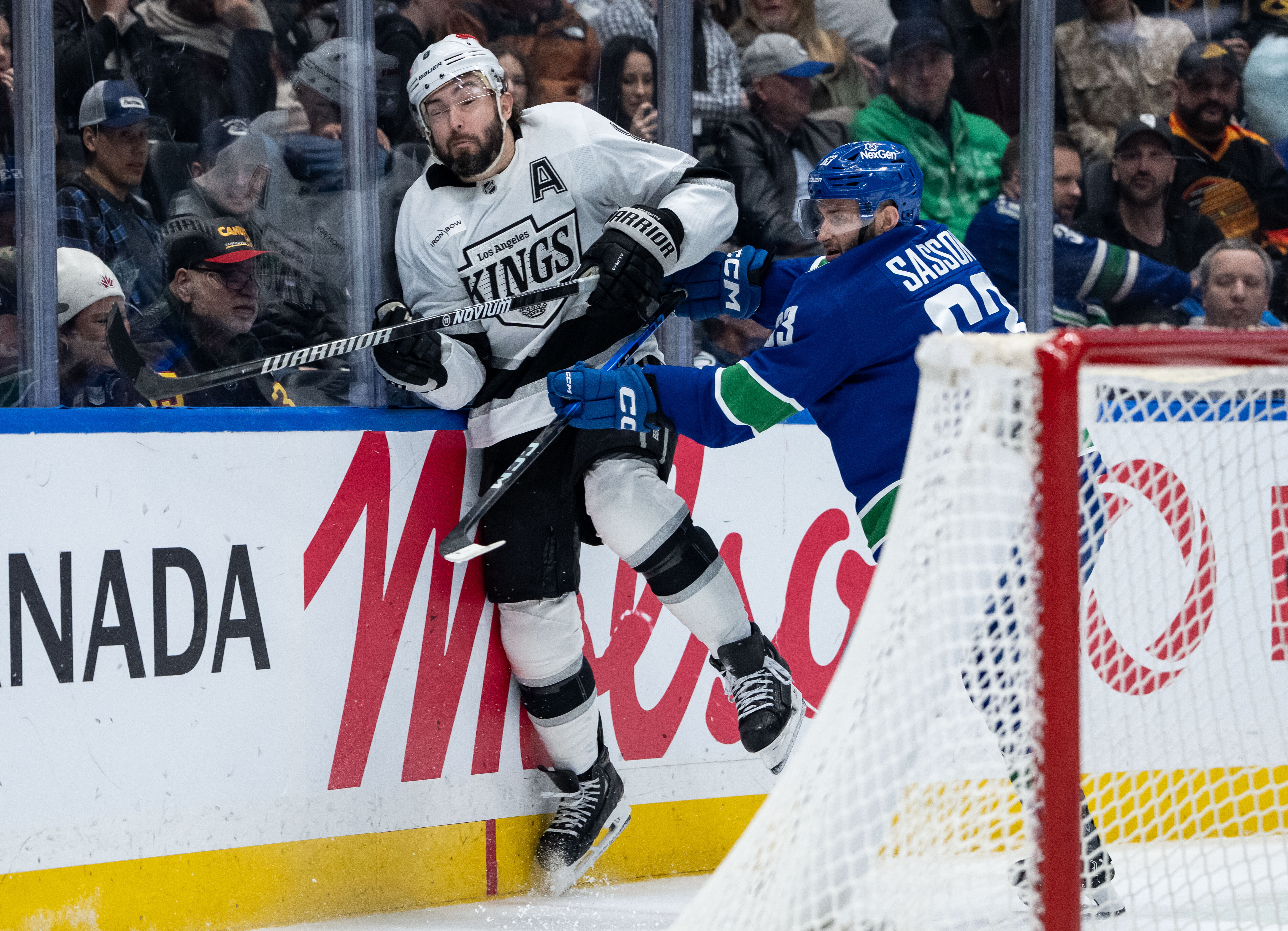 The Vancouver Canucks’ Max Sasson, right, hits Kings defenseman Drew...