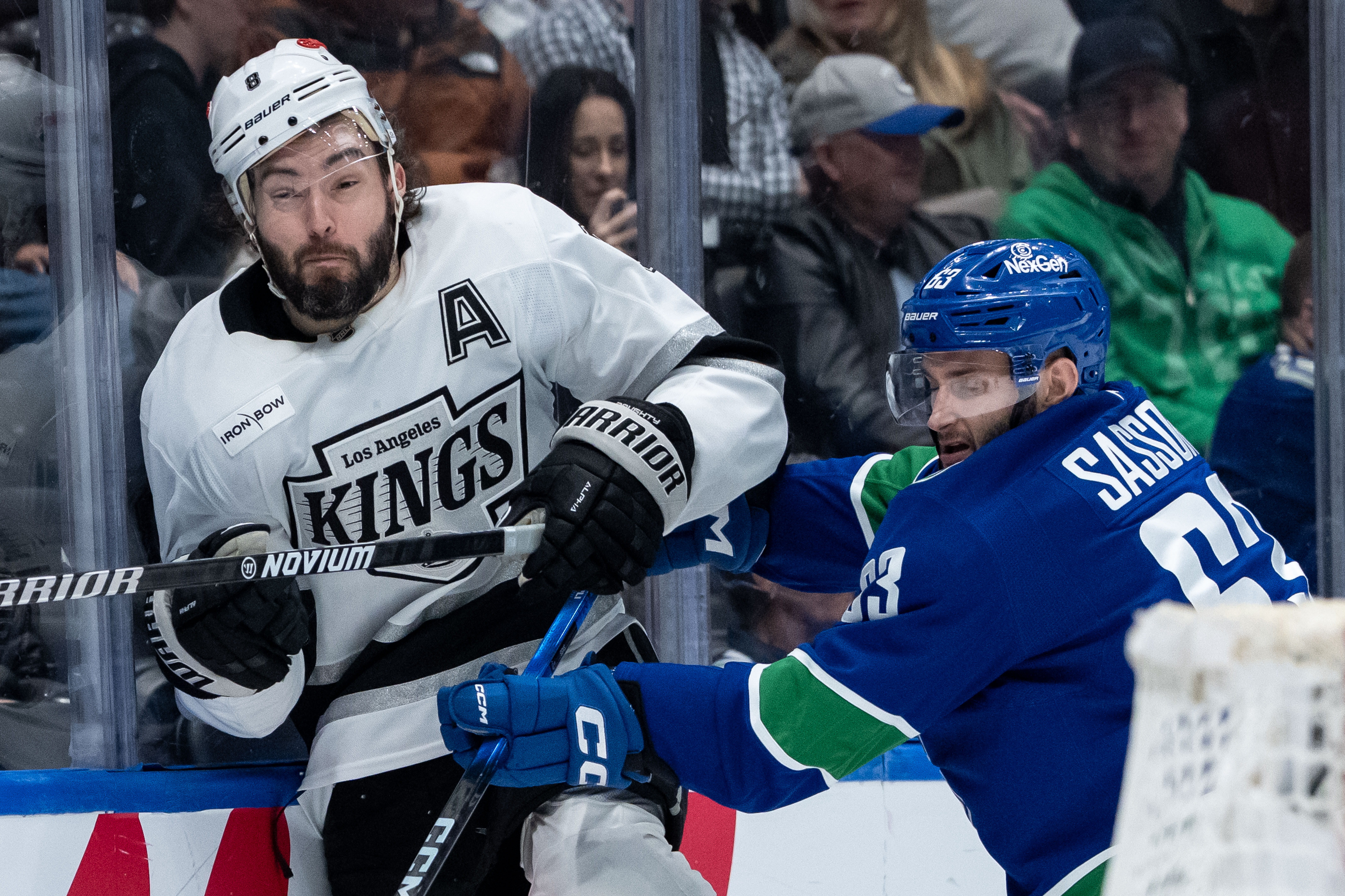 The Vancouver Canucks’ Max Sasson, right, hits Kings defenseman Drew...