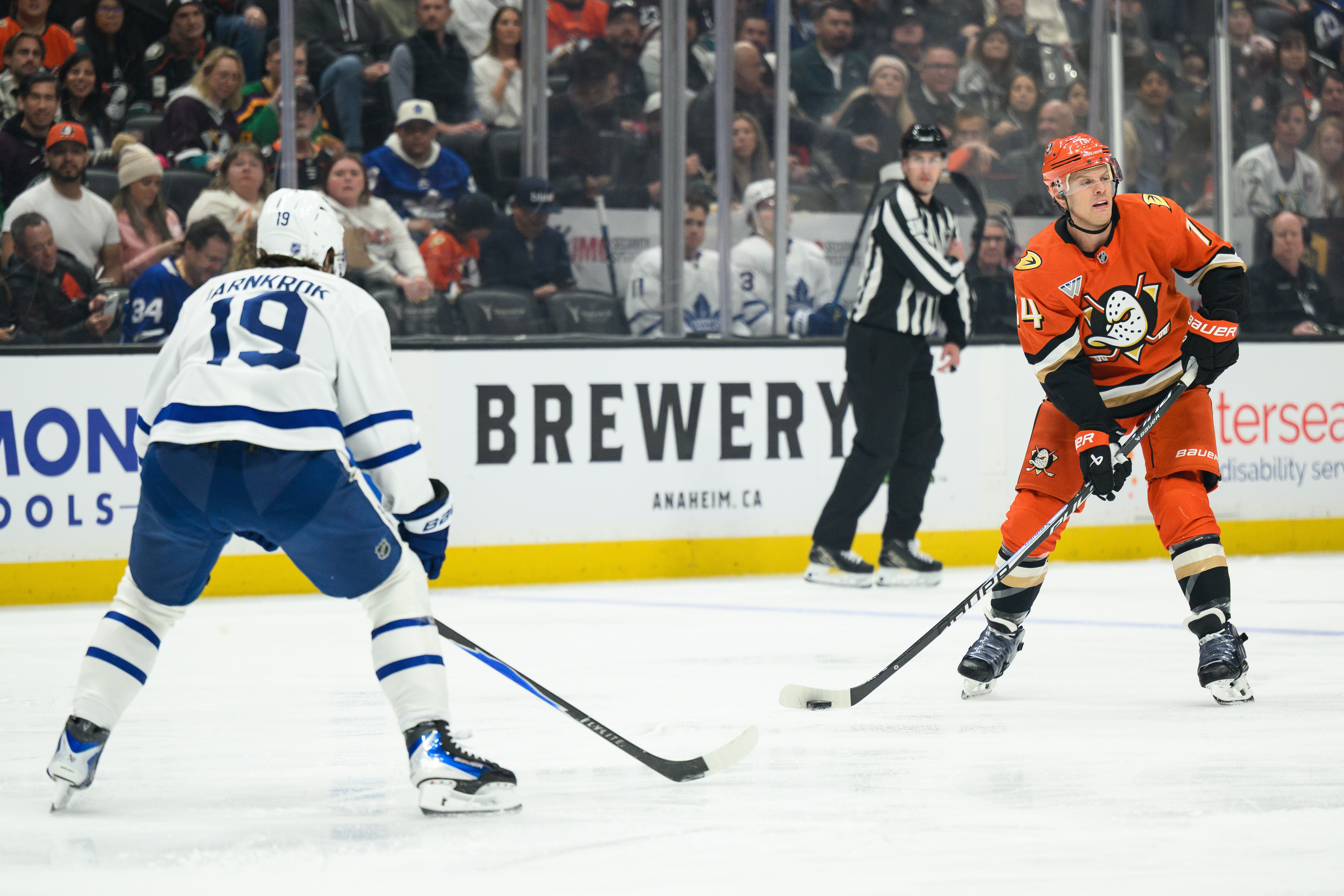 Ducks defenseman John Carlson, right, controls the puck while under...
