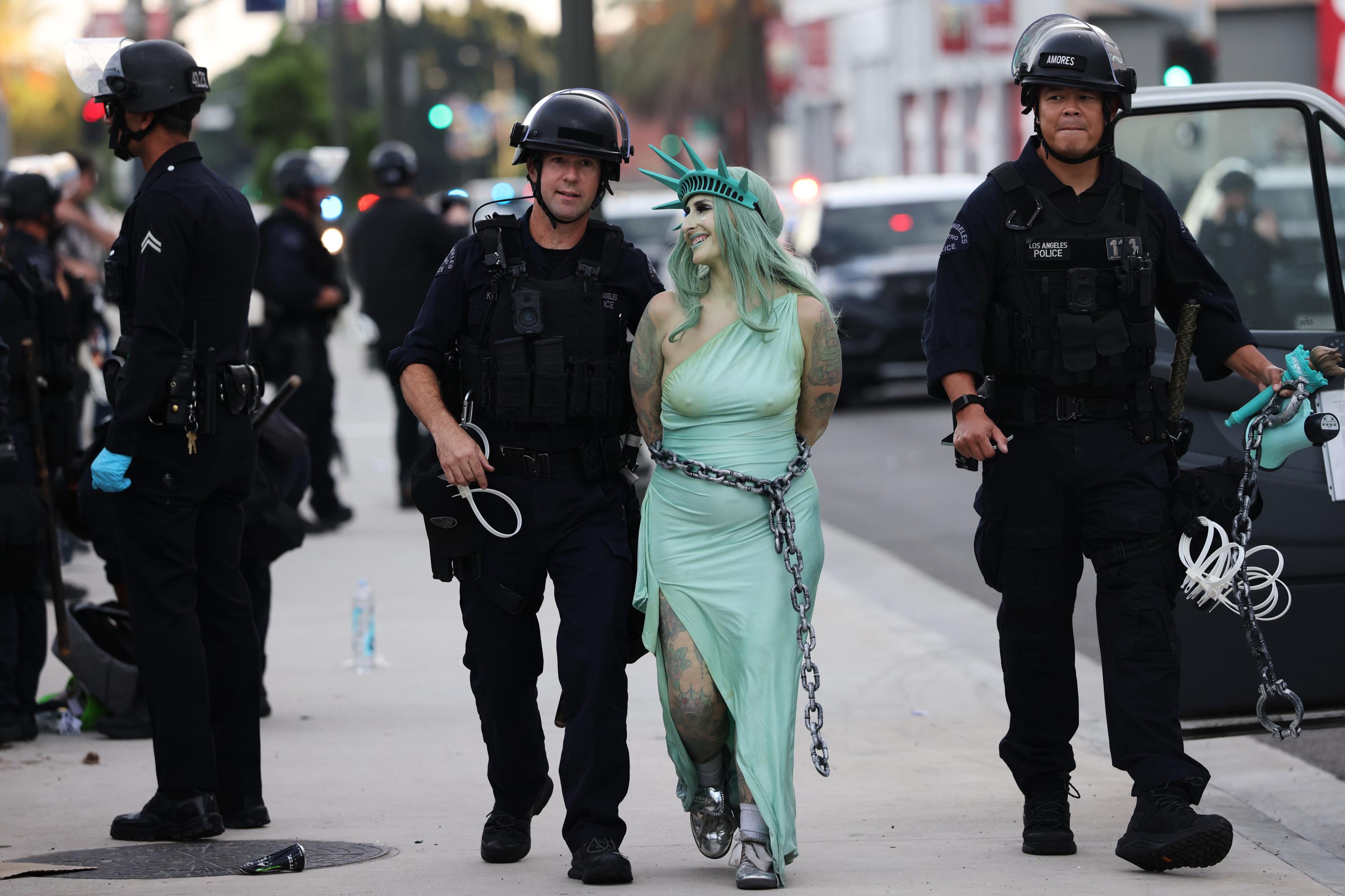 Police arrest a protester dressed as the Statue of Liberty, in downtown Los Angeles.