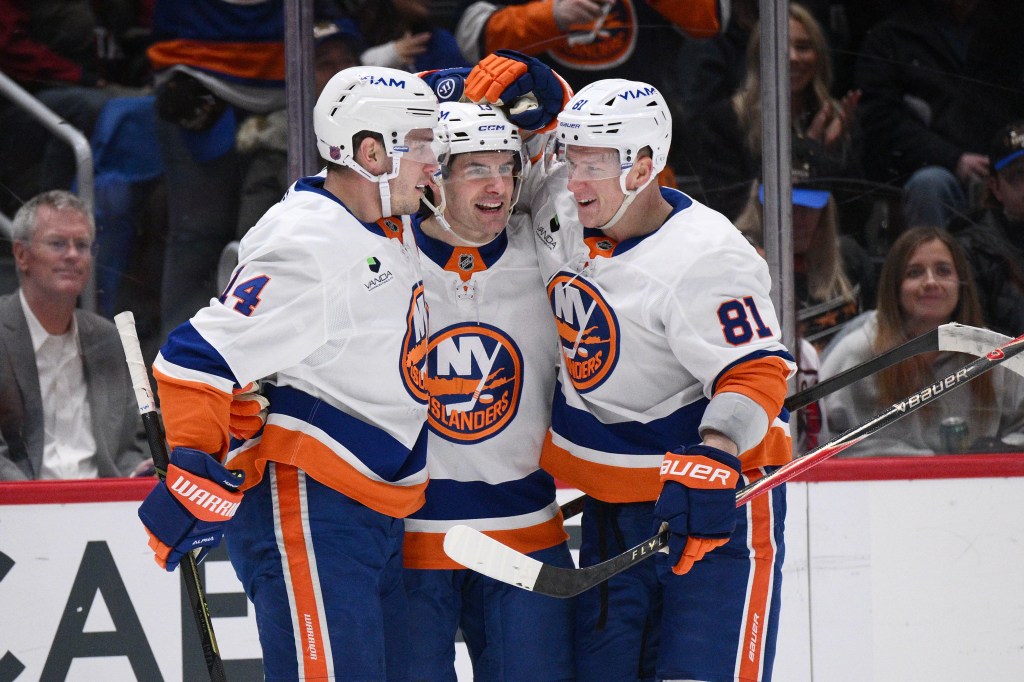 New York Islanders center Mathew Barzal, center, celebrates after his goal with center Bo Horvat (14) and left wing Ondrej Palat (81) during the first period of an NHL hockey game against the Washington Capitals, Monday, Feb. 2, 2026, in Washington.