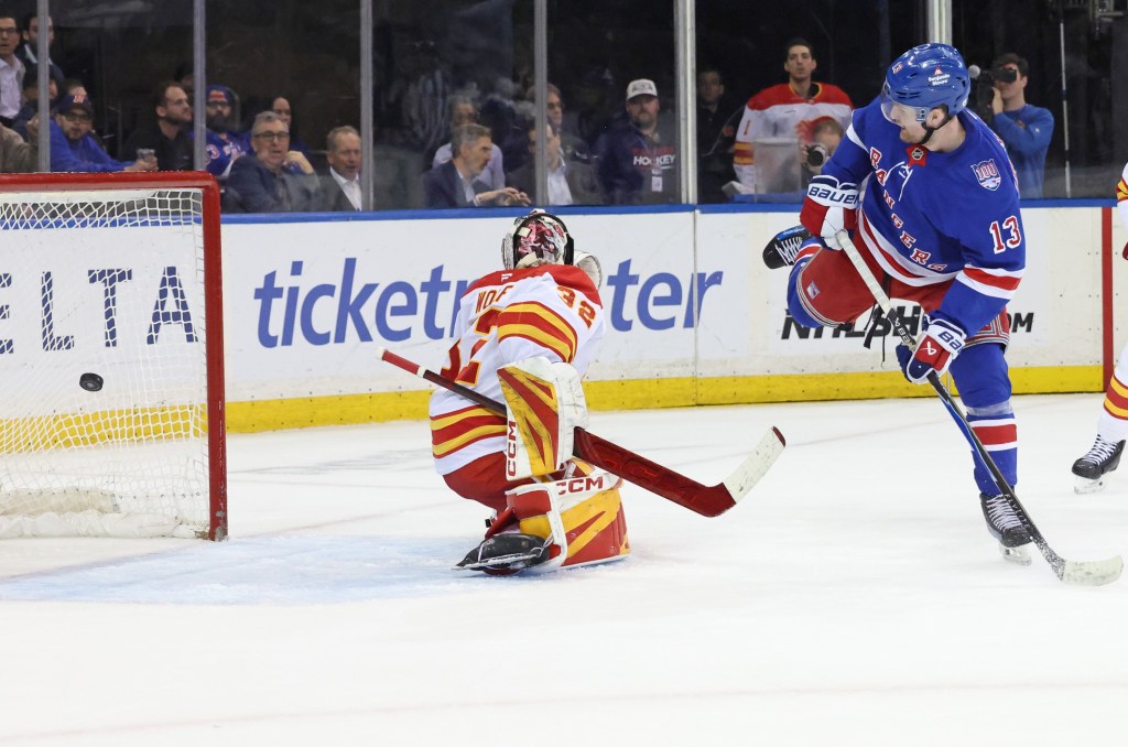 Alexis Lafrenière tips a puck past Dustin Wolf for the first of his three goals in the Rangers' 4-0 win over the Flames at the Garden on March 10, 2026.
