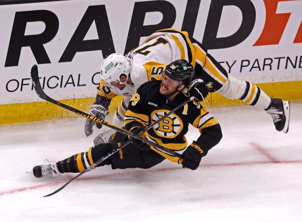 Boston Bruins right wing David Pastrnak (88) is dragged down by Pittsburgh Penguins defenseman Connor Clifton (75) for a holding penalty as the Bruins take on the Penguins at TD Garden. (Staff photo by Stuart Cahill)