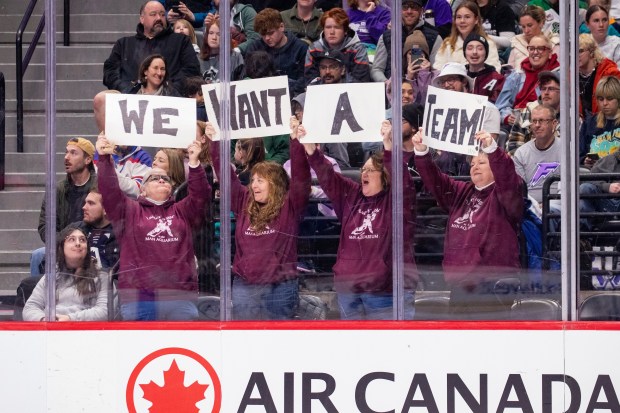 Colorado hockey fans hold up signs while standing along the glass at Ball Arena during Sunday's PWHL's Takeover Tour game in Denver. More than 15,000 were in attendance to see the Minnesota Frost hold off the New York Sirens, 4-3. (Danielle Hersch/PWHL)