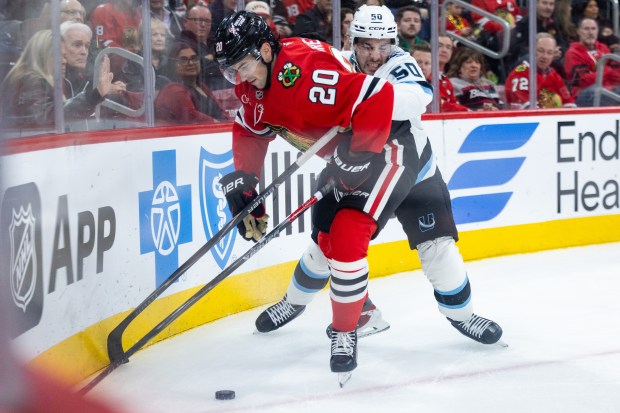 Chicago Blackhawks center Ryan Greene (20) keeps the puck away from Utah Mammoth defenseman Sean Durzi (50) in the first period against the Mammoth on Monday, March, 9, 2026, at the United Center. (Josh Boland/Chicago Tribune)
