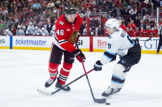 Chicago Blackhawks defenseman Louis Crevier (46) plays the puck against Utah Mammoth right wing Clayton Keller (9) in the second period against the Mammoth on Monday, March, 9, 2026, at the United Center. (Josh Boland/Chicago Tribune)