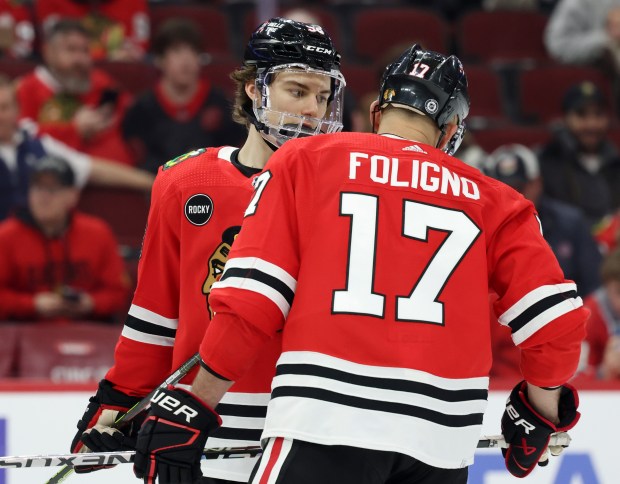 Blackhawks center Connor Bedard talks with left wing Nick Foligno against the Flyers on Feb. 21, 2024, at the United Center. (John J. Kim/Chicago Tribune)