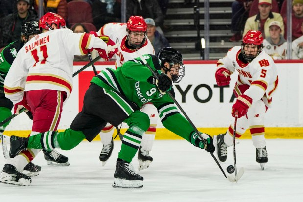 North Dakota's Sacha Boisvert (9) and Denver's Garrett Brown (5) battle for possession of the puck Feb. 14, 2025, in Denver. (Rebecca Slezak/Special to The Denver Post)