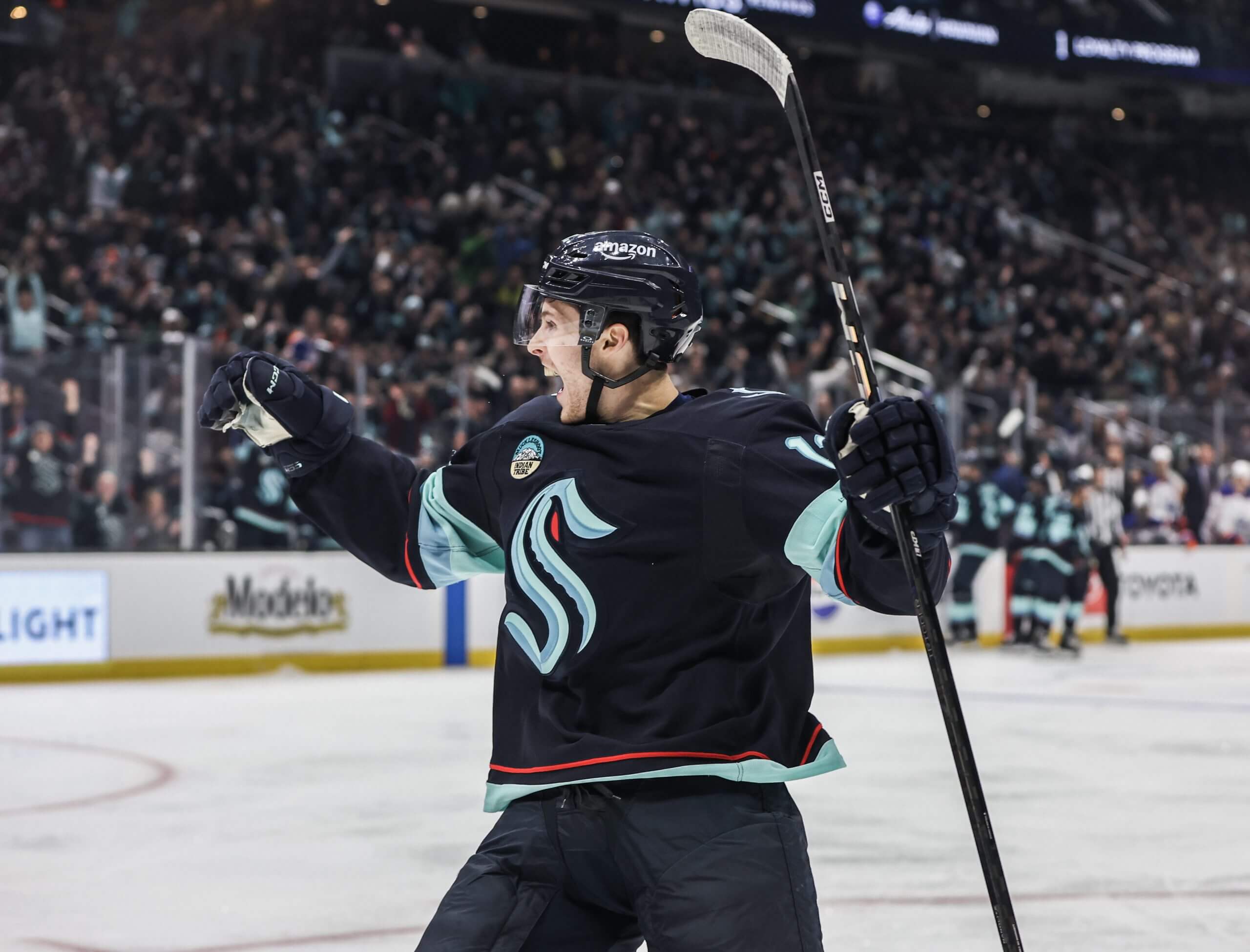 Tye Kartye, looking off to the left, raises his arms and cheers after scoring a goal for the Kraken.