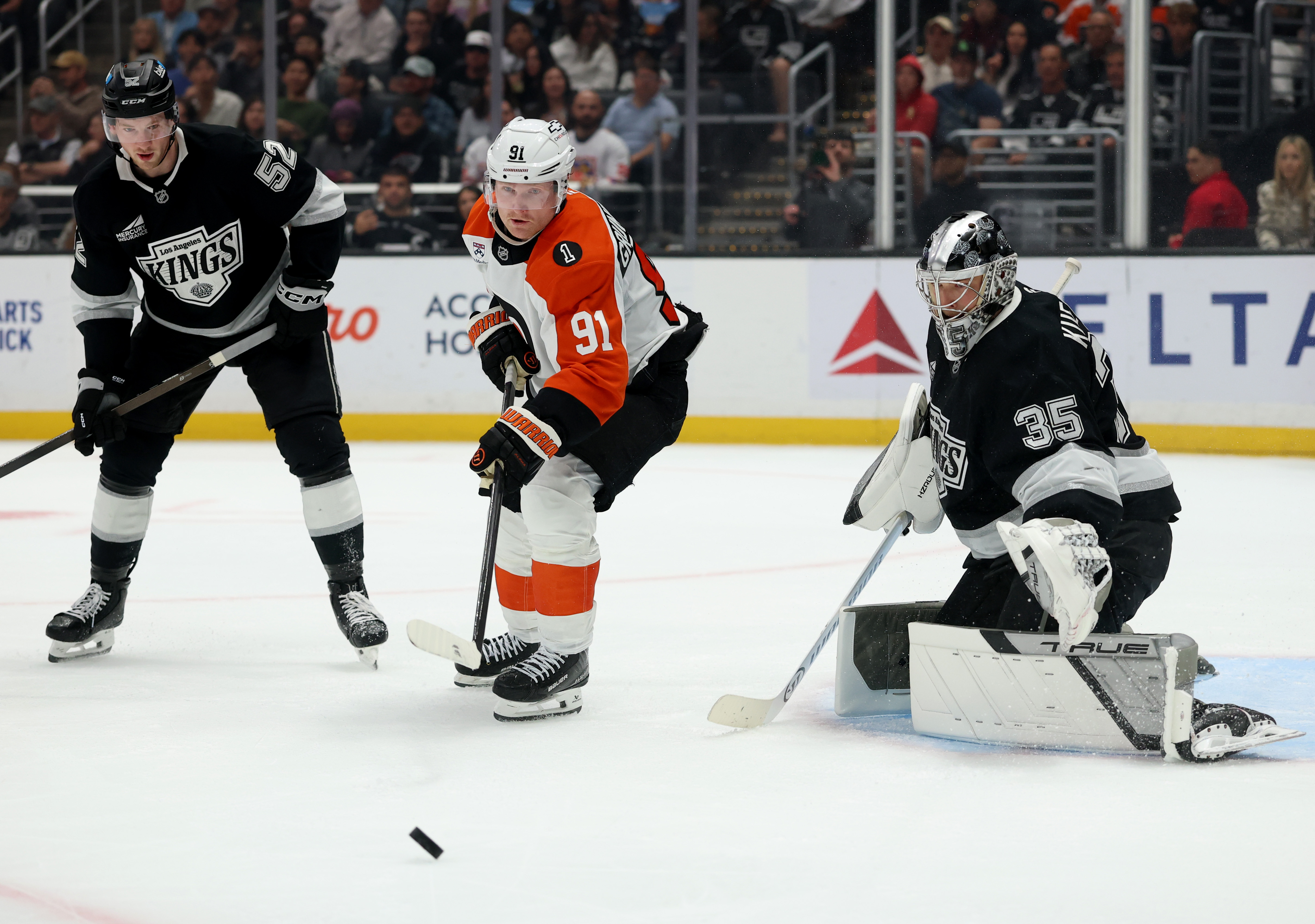 The Philadelphia Flyers’ Carl Grundstrom, center, looks for a rebound...