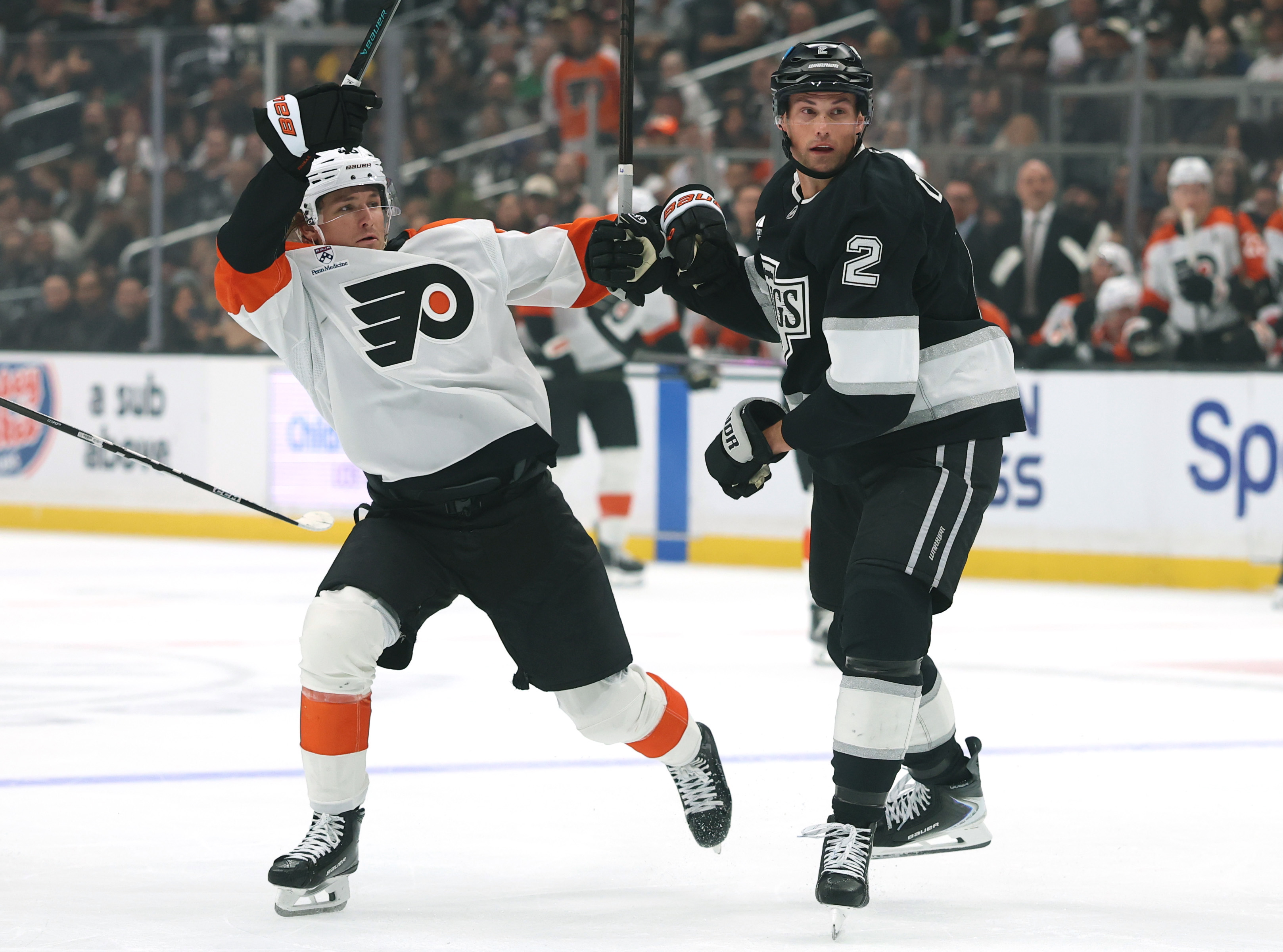 The Philadelphia Flyers’ Trevor Zegras, left, is bumped off stride...