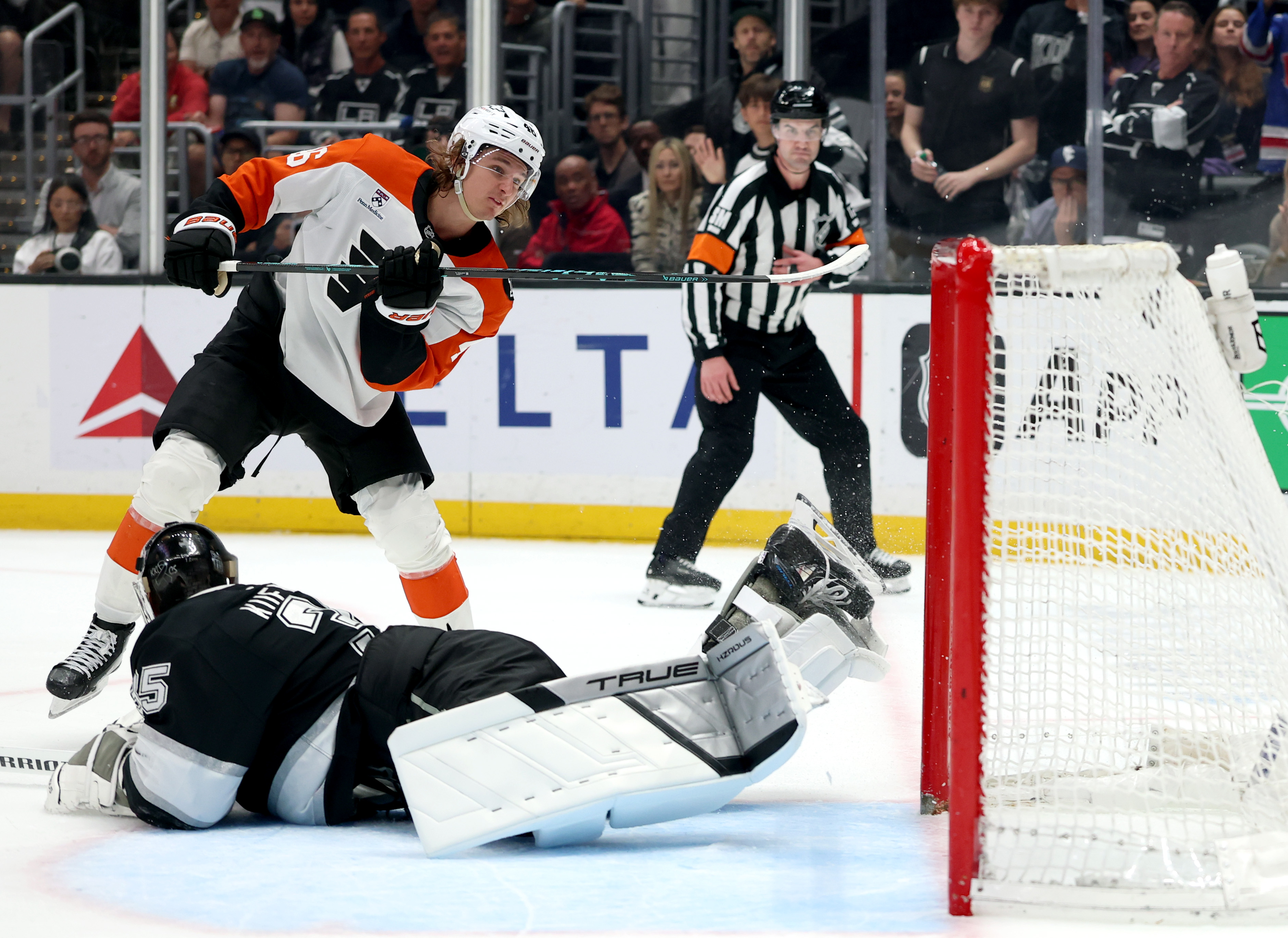 The Philadelphia Flyers’ Trevor Zegras, top, scores a shootout goal...