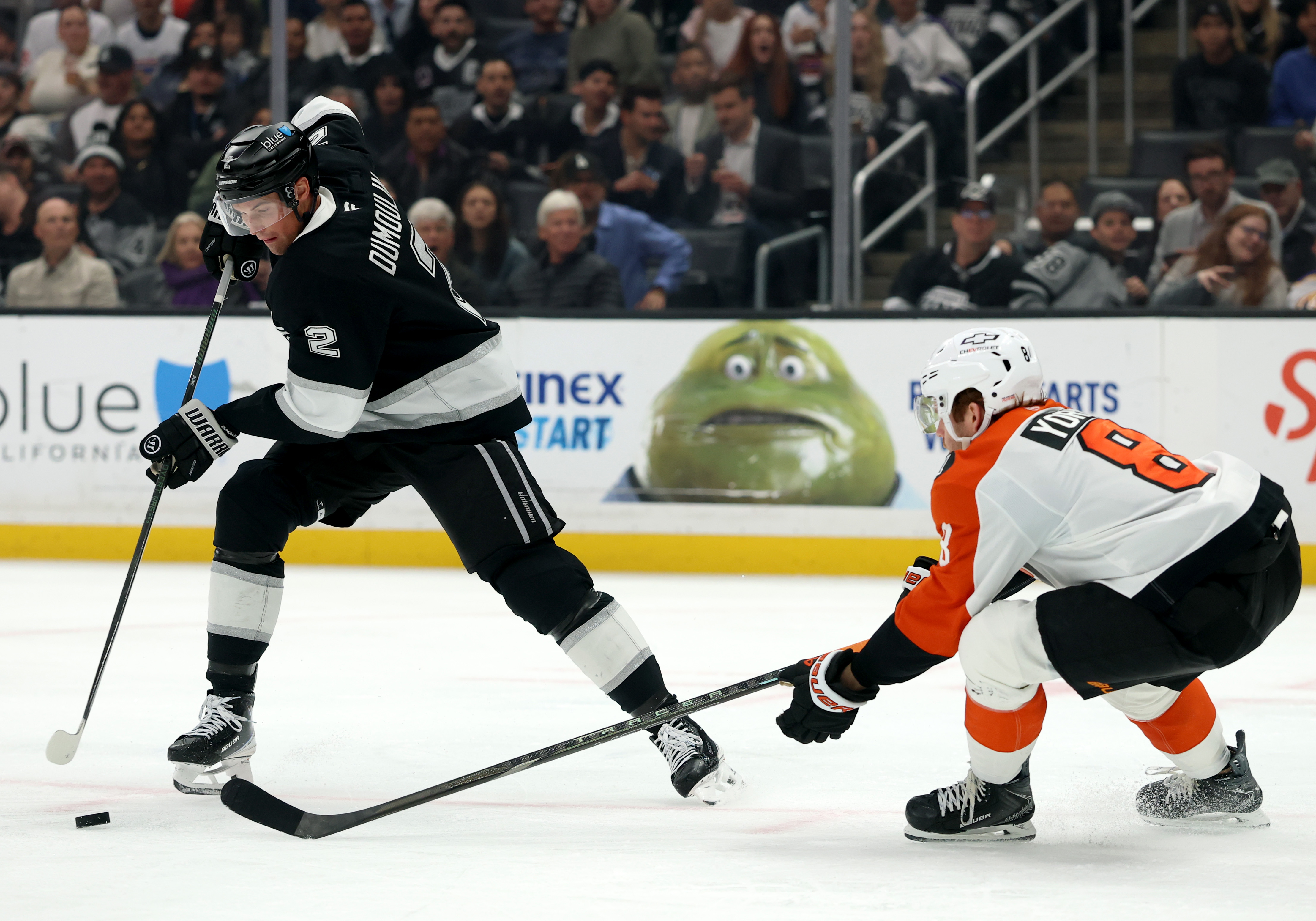 The Kings’ Brian Dumoulin, left, stick handles his way around...