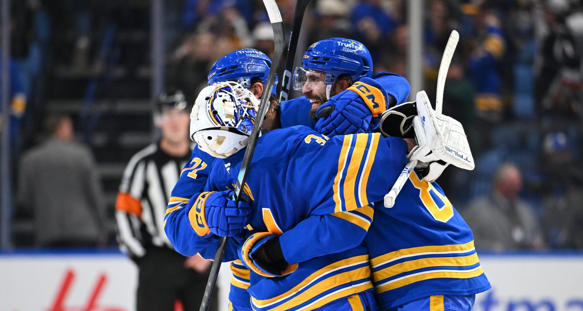Alex Tuch #89 and Ryan McLeod #71 celebrate with teammate Alex Lyon #34 of the Buffalo Sabres after winning an NHL game against the Toronto Maple Leafs