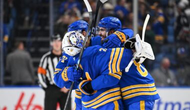 Alex Tuch #89 and Ryan McLeod #71 celebrate with teammate Alex Lyon #34 of the Buffalo Sabres after winning an NHL game against the Toronto Maple Leafs