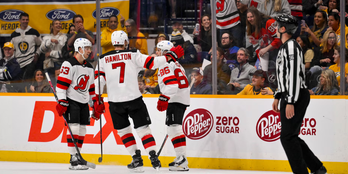 New Jersey Devils' skaters Jesper Bratt, Dougie Hamilton and Jack Hughes celebrate a goal with fans in the first period of Thursday's contest against the Nashville Predators.