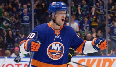 Vancouver Canucks center Elias Pettersson, wearing the 'Flying Skate' retro jersey, celebrating a goal, amidst New York Islanders trade speculation.