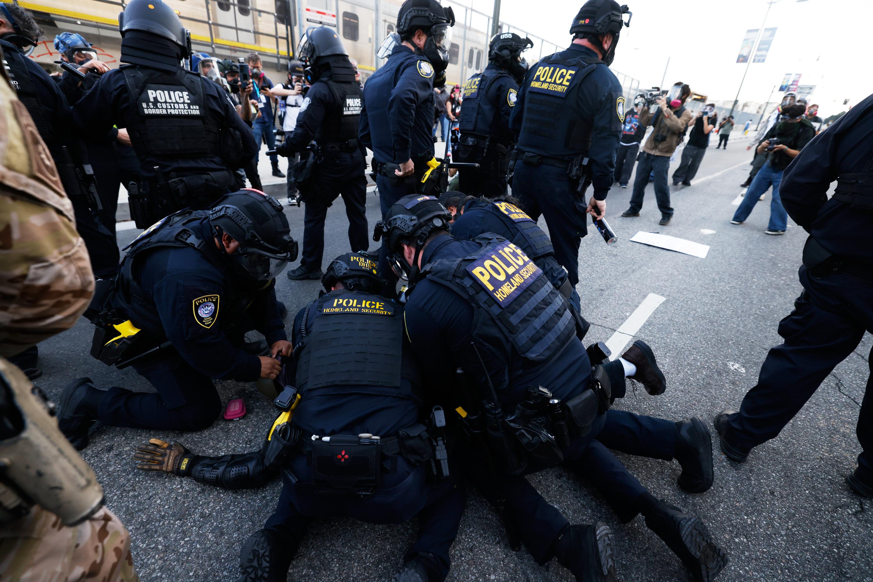 Police detain a protester near the Metropolitan Detention Center in downtown Los Angeles.