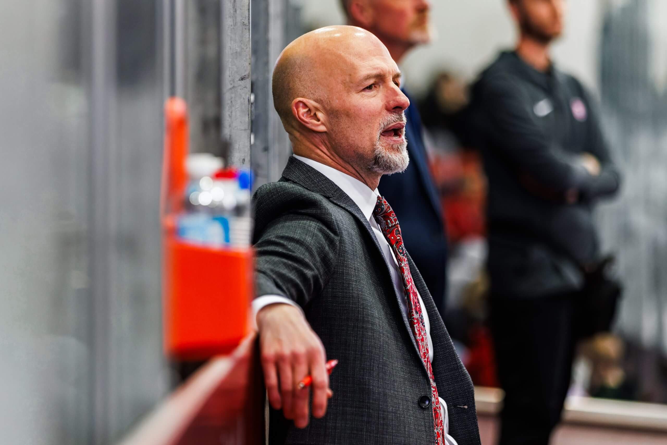 Brett Larson leans back against a wall, holding a pen, during a Huskies game.